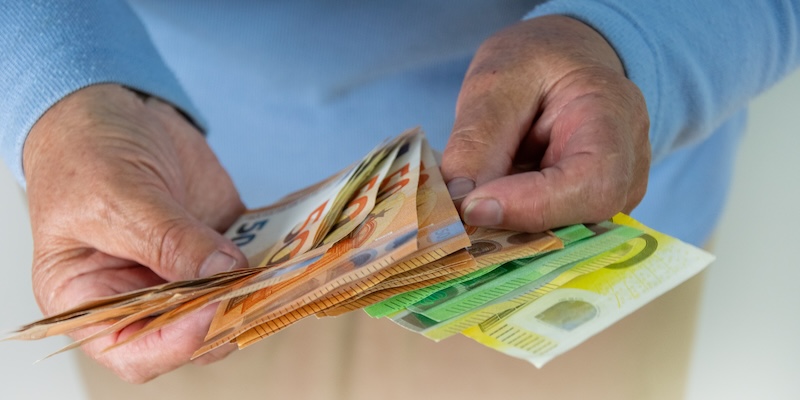 Hände voller Geldscheine – Symbolbild für Scalable Capital Bonus Depotwechsel AB